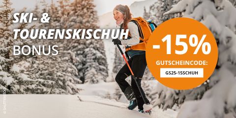 Nahaufnahme einer Person, die die Bindungen ihrer Skischuhe einstellt, umgeben von Schnee. Das Bild enthält einen Werbetext, der mit einem Code einen Rabatt von 15 % anbietet. Die Skischuhe sind blau und mit der Marke „Atomic“ versehen.