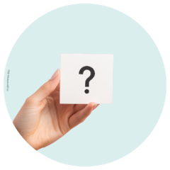 Eine Hand hält eine weiße Karte mit einem großen schwarzen Fragezeichen vor einem hellblauen runden Hintergrund.